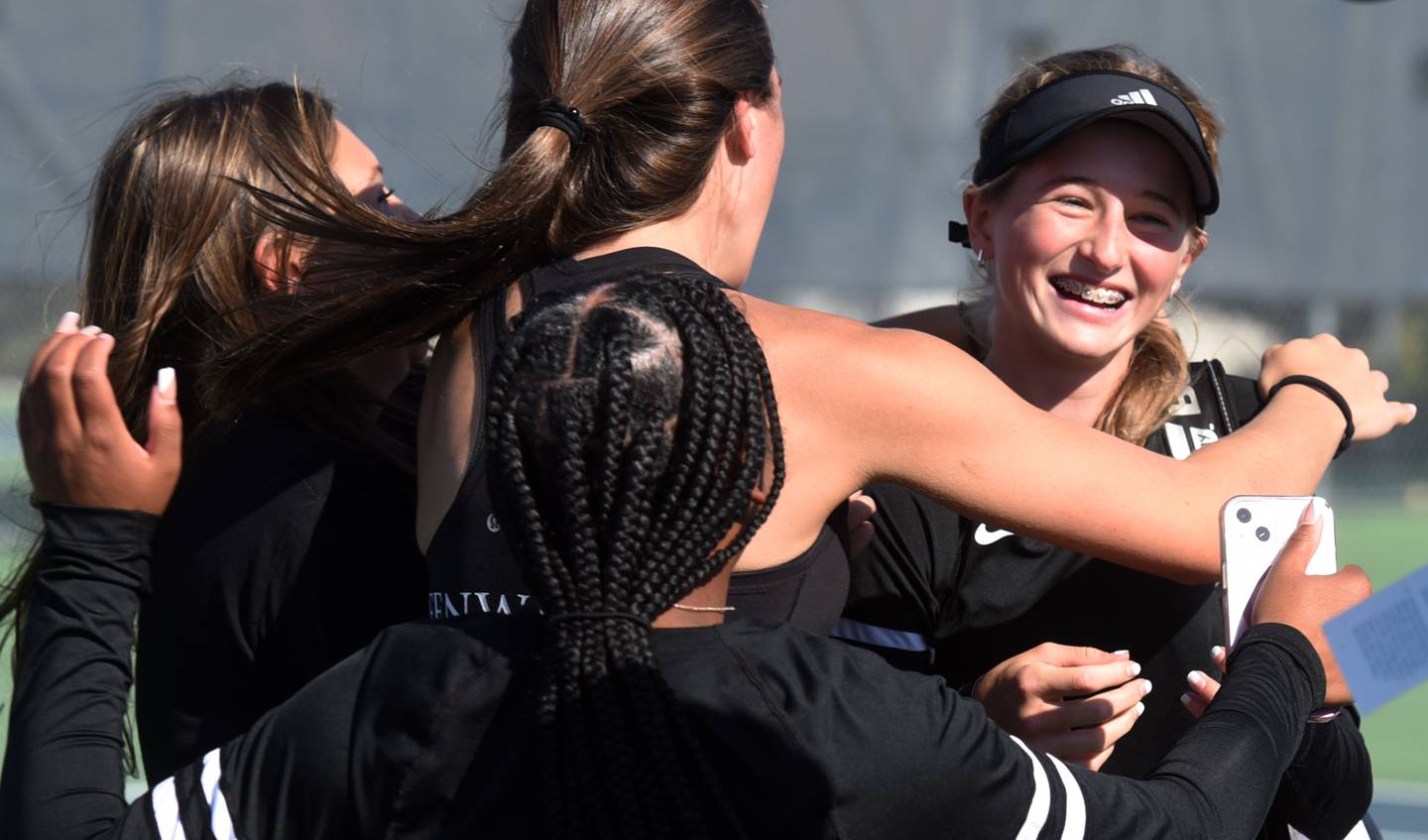 Fenwick’s Lily Brecknock, right, celebrates her Class 1A singles state championship with her teammates during the girls state tennis meet in Buffalo Grove Saturday.