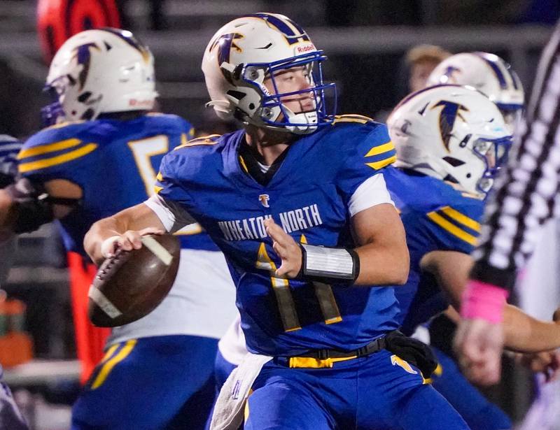 Wheaton North's Max Howser (11) sits in the pocket and looks downfield against Geneva during a football game at Wheaton North High School on Friday, Oct. 6, 2023.