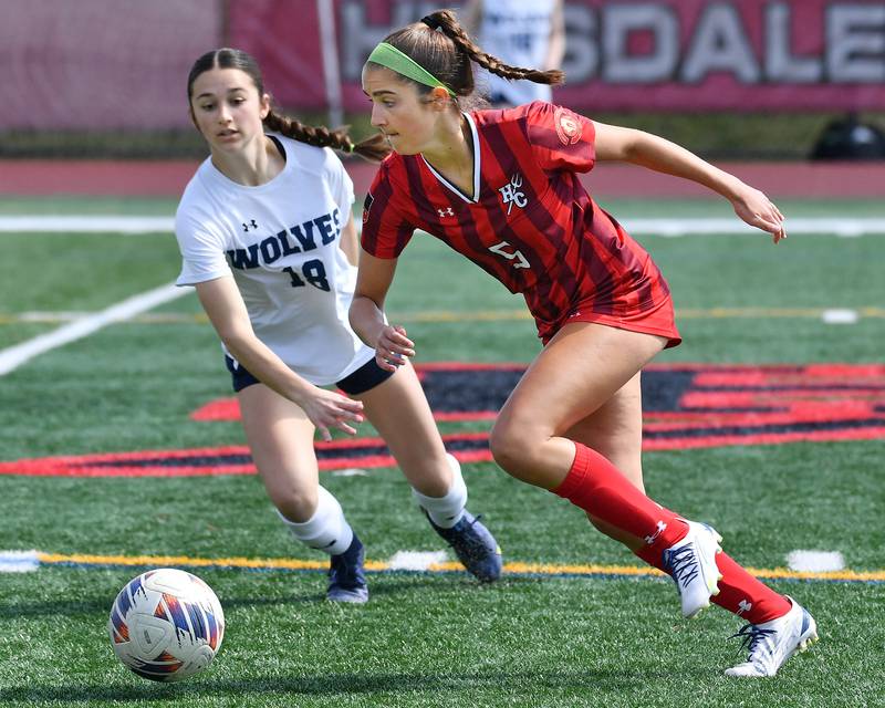 Hinsdale Central's Emily DiTomasso (5) advances the ball as Oswego East's Ashley Gumm defends during a match on March, 30, 2024 at Hinsdale Central High School in Hinsdale.