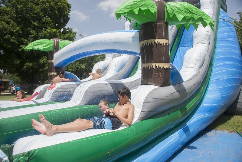 Declan Oliver, 10, chills out as a fellow SPARK camper cruises by on the water slide Wednesday in Dixon.