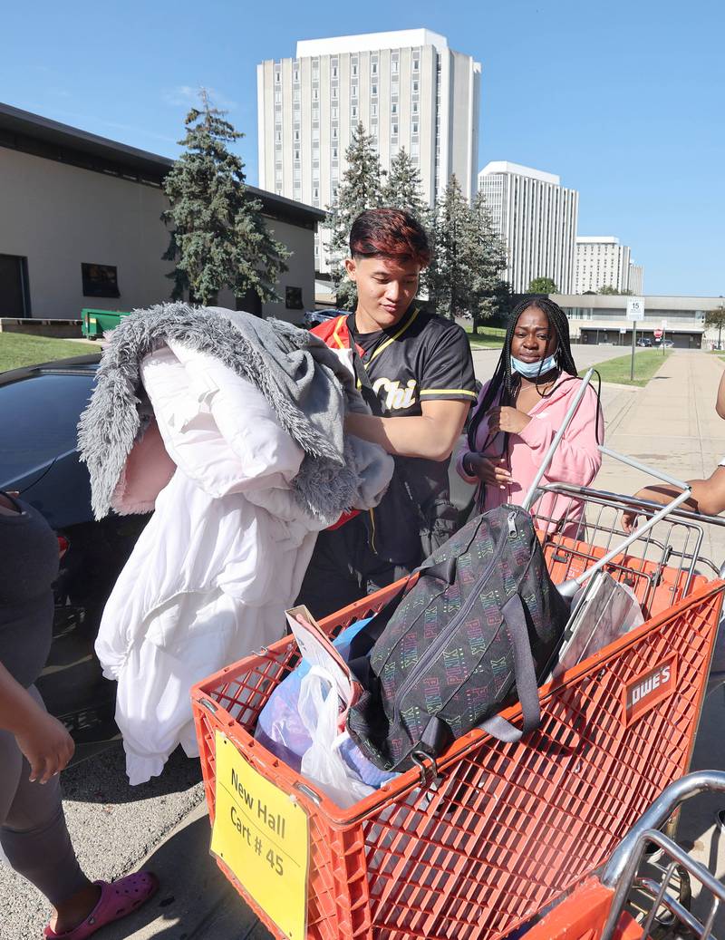 Northern Illinois University junior Tiara Smith, from Chicago, gets some help unloading her car from volunteer Harju Ree, a member of the Delta Chi fraternity, Thursday, Aug. 18, 2022, as she moves into New Residence Hall at NIU. Thursday was one of four move-in days for students attending the upcoming school year.