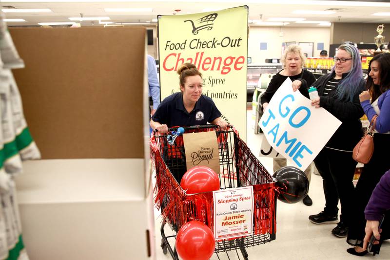 Kane County State’s Attorney Jamie Mosser takes off for the Kane County Farm Bureau's 23rd Check Out Shopping Spree at the Jewel-Osco in Batavia on Monday, Feb. 26, 2024. Mosser collected food for Elgin's Community Crisis Center.​