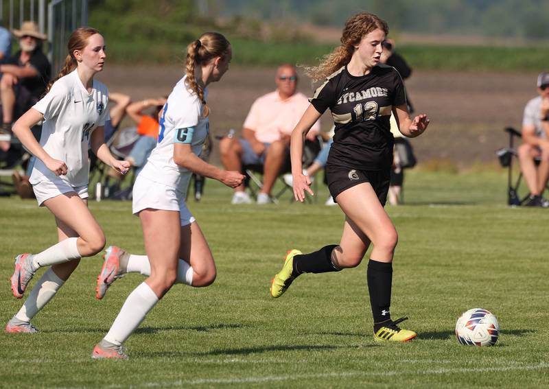 Sycamore's Kate Elsner gets behind two Woodstock players and scores a goal during their Class 2A regional semifinal game Wednesday, May 15, 2024, at Kaneland High School in Maple Park.