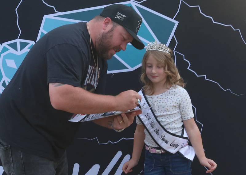 Country Music star Mitchell Tenpenny, signs an autograph for Charlee Kruse, Little Miss Bureau County Fair, during the 169th Bureau County Fair on Thursday, Aug. 22, 2024 in Princeton.