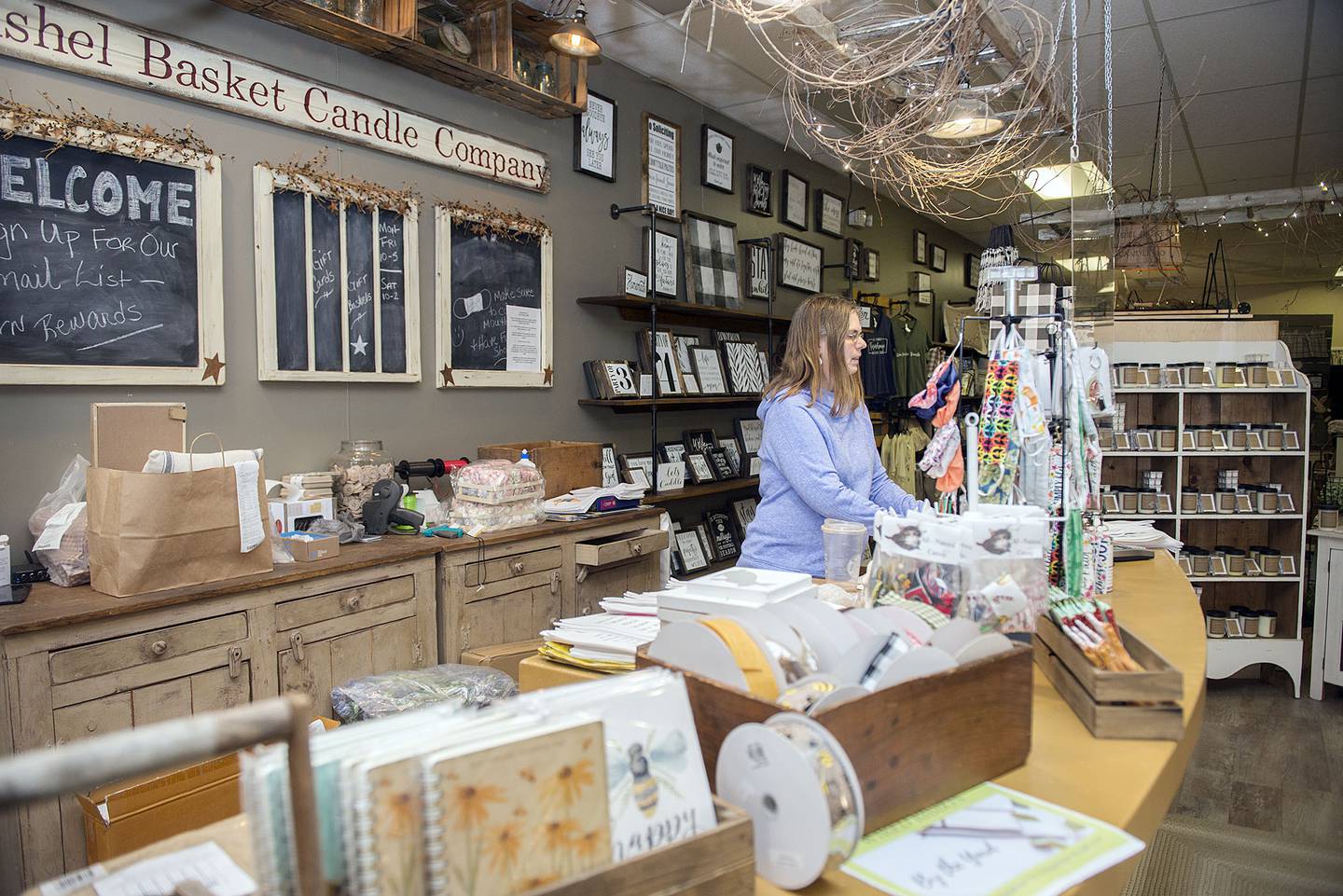 Jackie Payne, owner of Bushel Basket Candle Company, works at her counter Thursday, Feb. 17, 2022. The store has been a stalwart at the mall and will remain unchanged, but Payne and family will be opening a separate toy store.