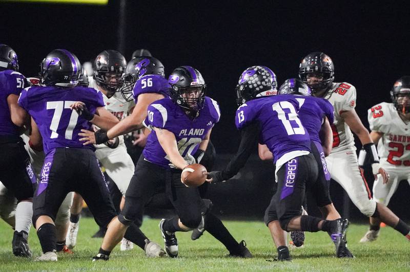 Plano's Kaiden Schimandle (10) hands the ball off to Amari Bryant (13) during a football game against Sandwich at Plano High School on Friday, Sep 13, 2024.