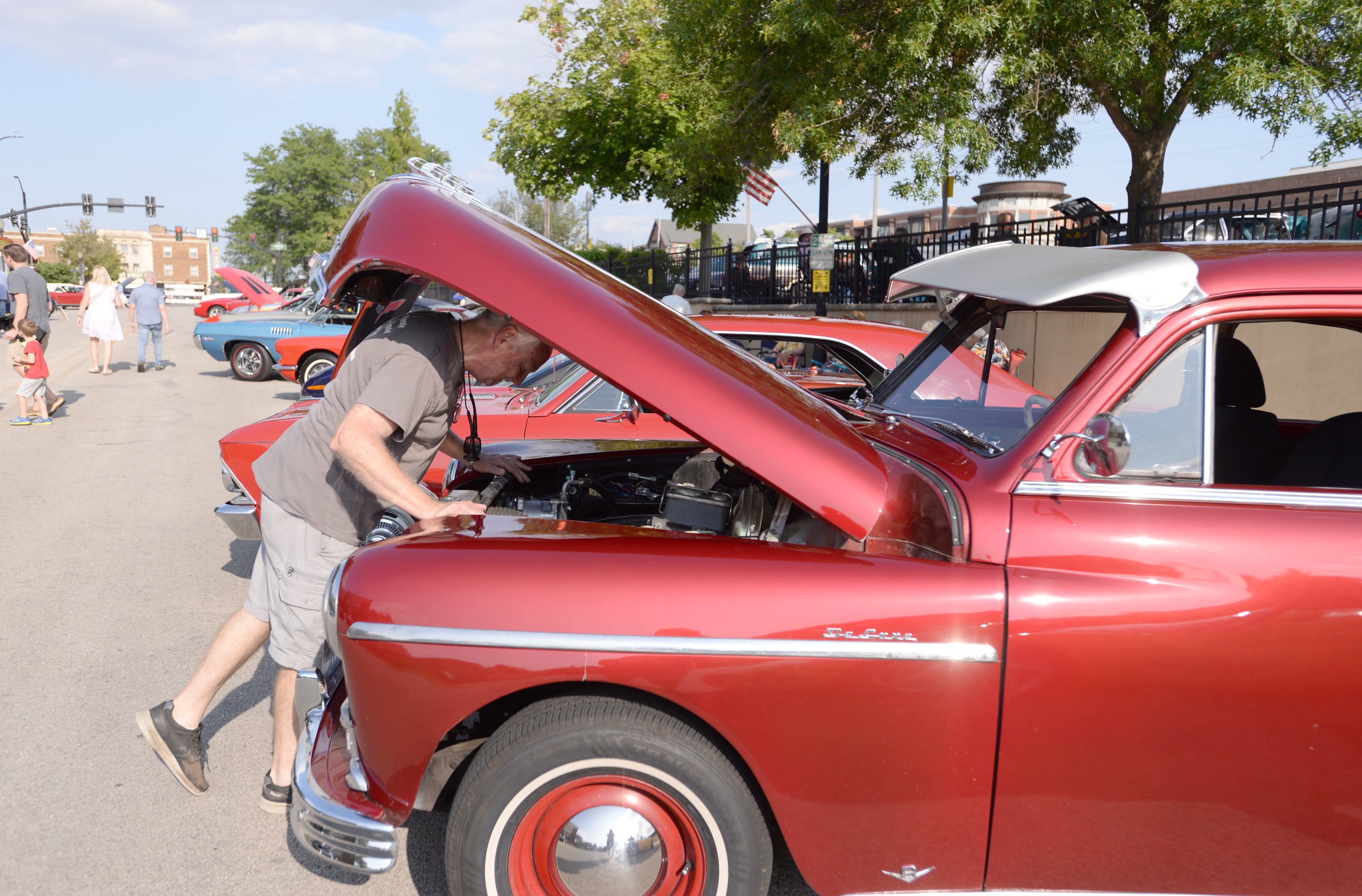 Tom Culver of Wheaton checks under under his 1949 Plymouth hood during the Downers Grove Car Show Friday July 19, 2024.