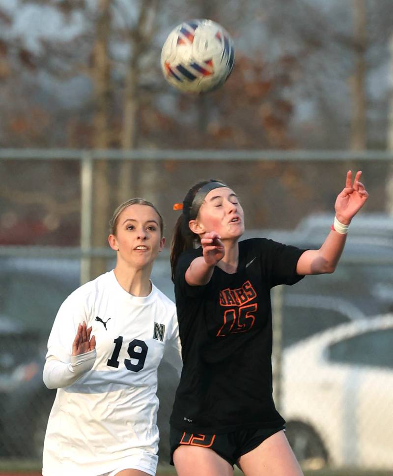 DeKalb’s Quinn McLane heads the ball in front of Belvidere North's Aubrey Mcgaw during their game Tuesday, March 12, 2024, at DeKalb High School.