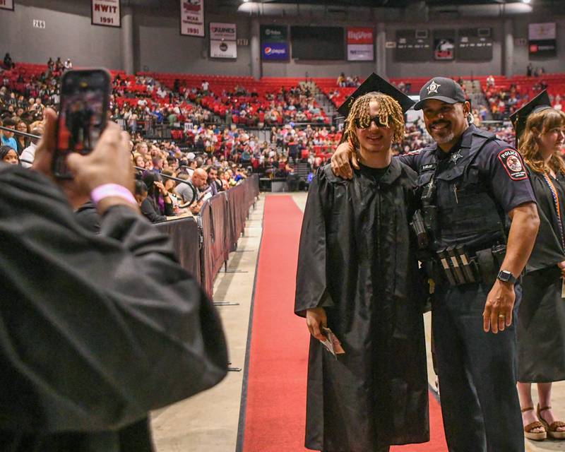 Talen Tate poses for a photo with his godfather and NIU police officer, Daniel Mojica, before walking across the stage to accept his diploma during the DeKalb High School 2024 Commencement held at the NIU Convocation Center in DeKalb.