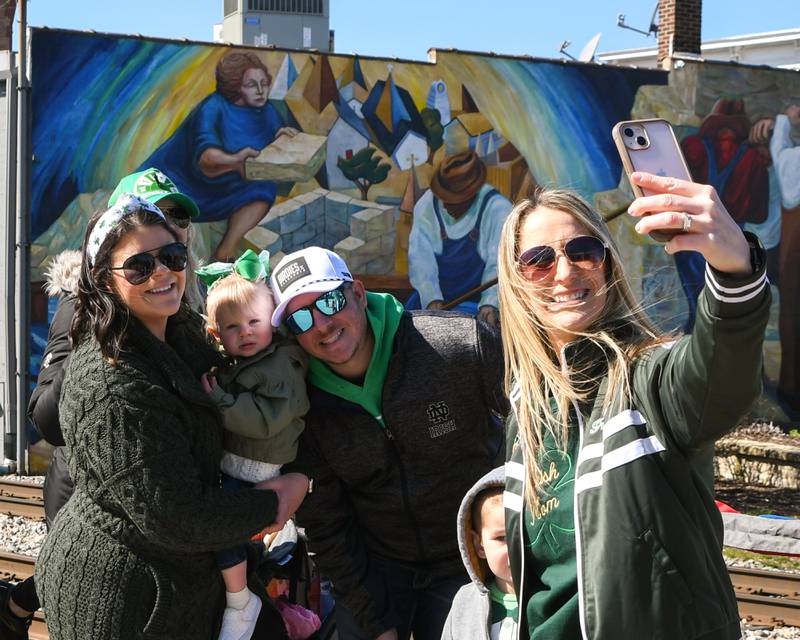 Shannon Ryla of Lemont takes a selfie with friends Bridge, Scarlett, two and half,  and Tyler Cizek pose for a photo during the St. Patrick’s Parade on Saturday March 9, 2024 in downtown Lemont.