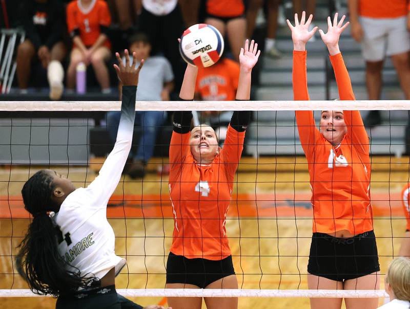 DeKalb's Maddi Hollar (left) and Ava Wente try to block the spike of Sycamore's Khiara  Thomas during their match Wednesday, Aug. 28, 2024, at DeKalb High School.