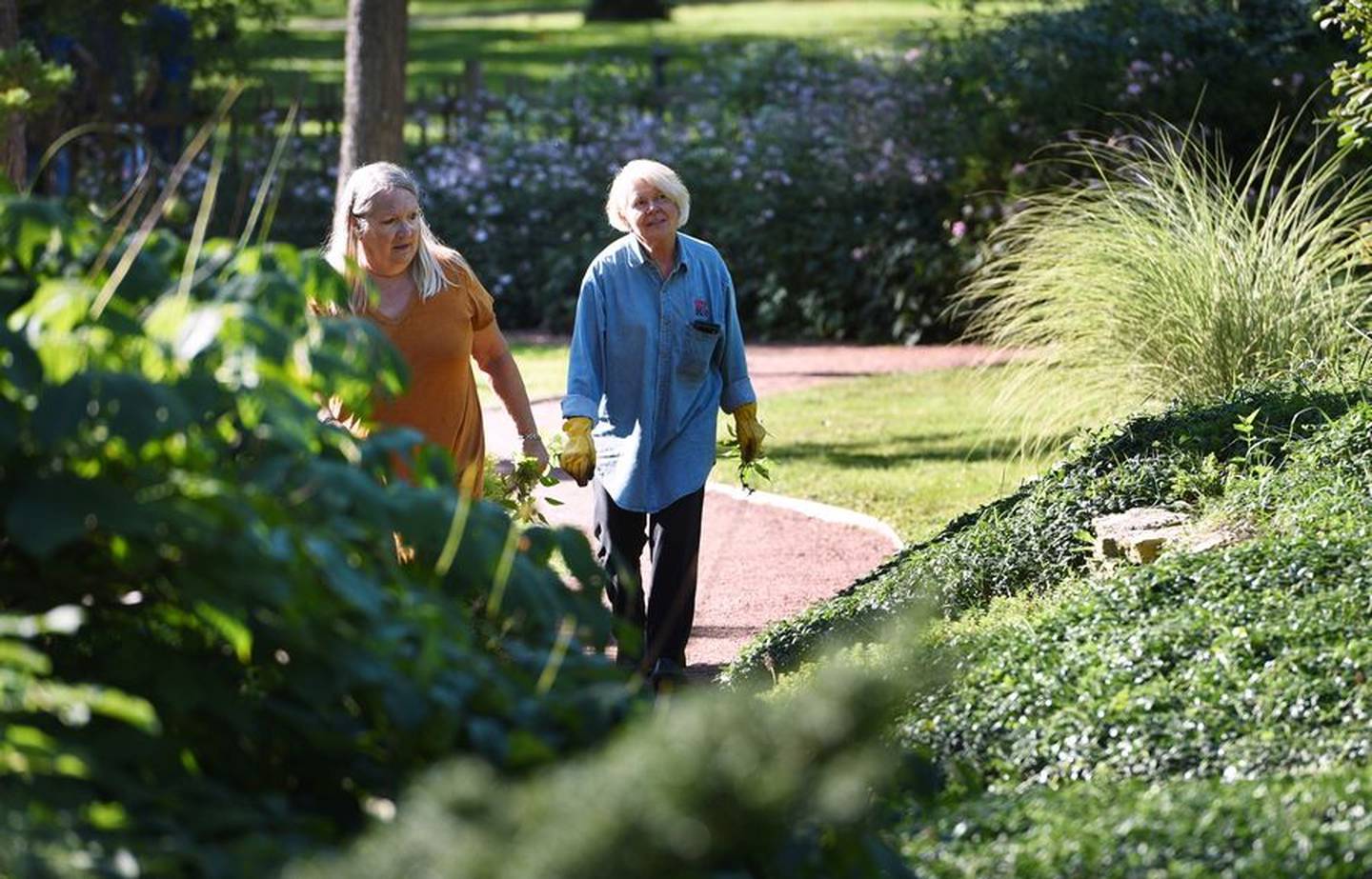 Geneva Garden Club members Linda Bradley, left, and Bobbi Higham walk one of the paths in the Japanese Tea Garden at Fabyan Forest Preserve in Geneva. Members of the club have been working to restore the gardens.