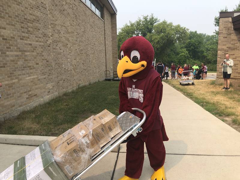 Hilly, the mascot at McHenry School District 15's Hilltop Elementary School, helps unload $40,000 in school supplies donated by Enchanted Backpack on June 15, 2023.