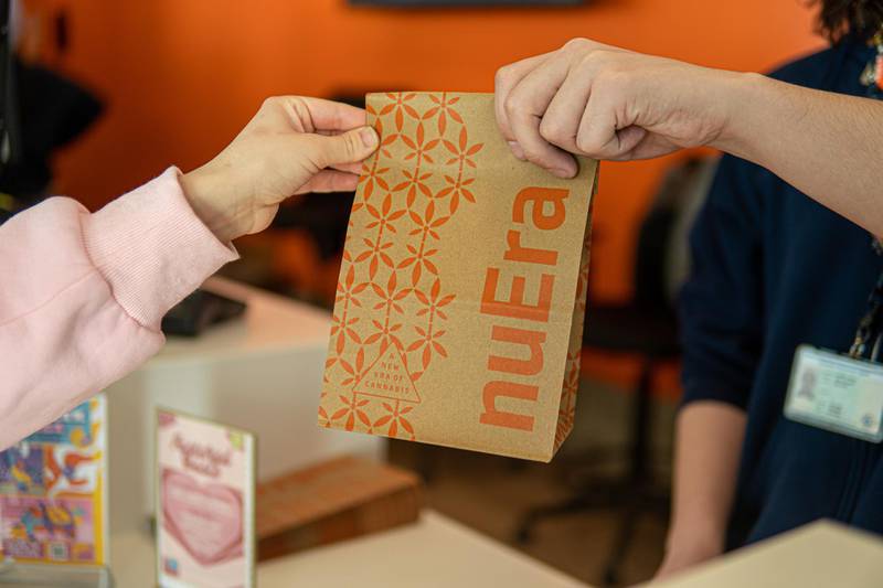 A NuEra exit bag being handed to a customer at one of NuEra dispensary's locations. NuEra will open its DeKalb location at 818 W. Lincoln Highway in The Junction Shopping Center on May 23, 2024.