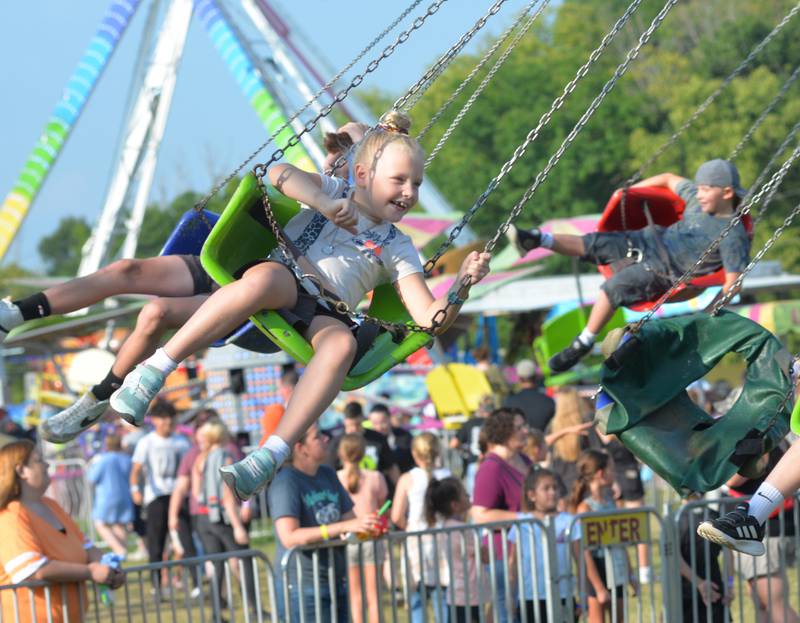 Ava Jones, 7, of Dixon, smiles as she rides the swings at the Ogle County Fair on Saturday, Aug. 5, 2023.