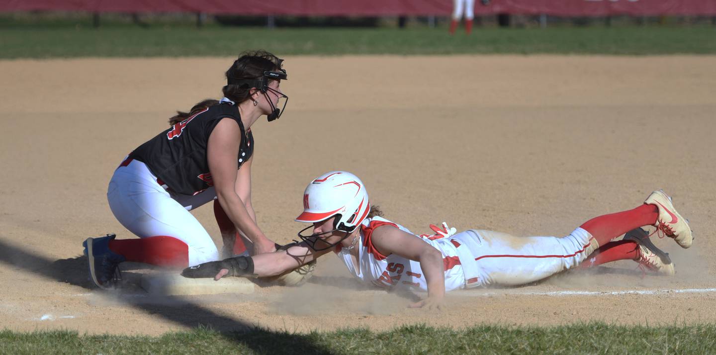 Naperville Central's Sydney Hurst, right, slides safely back into third base as Benet's Angela Horejs applies the tag during Wednesday’s softball game in Naperville.