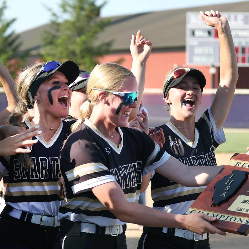 Sycamore players celebrate as they receive the Class 3A regional champions plaque after beating Dixon Thursday, May 23, 2024, at Rochelle High School.