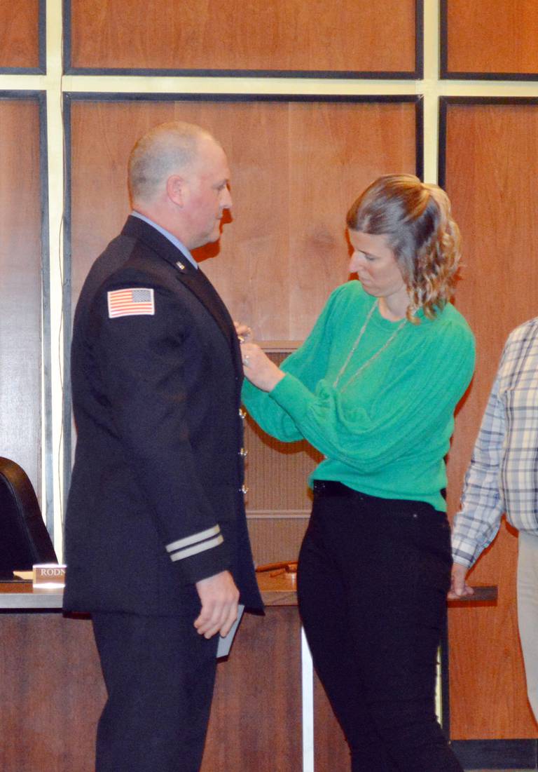 Melissa Newton, right, pins a badge on her husband, Derick Newton, after he was sworn in as a Rock Falls Fire Department captain during the Tuesday, March 5, 2024, Rock Falls City Council meeting.