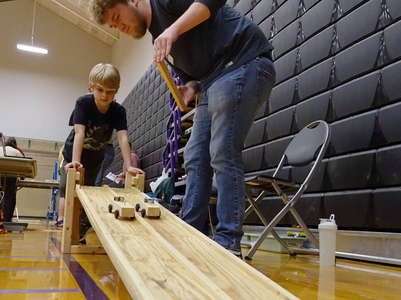 Ashton Watkins demonstrates how weight affects gravity using wooden cars on Friday, April 19, 2024, at Illinois Valley Community College's SciFest.