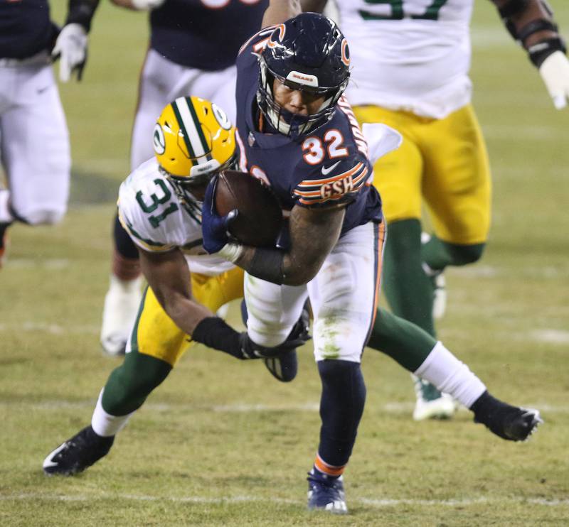 Chicago Bears running back David Montgomery (32) breaks the tackle attempt of Green Bay Packers strong safety Adrian Amos (31) during their game Sunday at Soldier Field in Chicago.