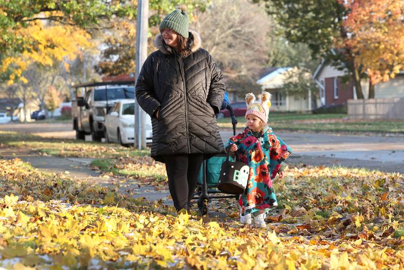 Mabel Leonard, 2, walks with her mom Tabitha as they trick-or-treat on a chilly Halloween Tuesday, Oct. 31, 2023, in DeKalb.