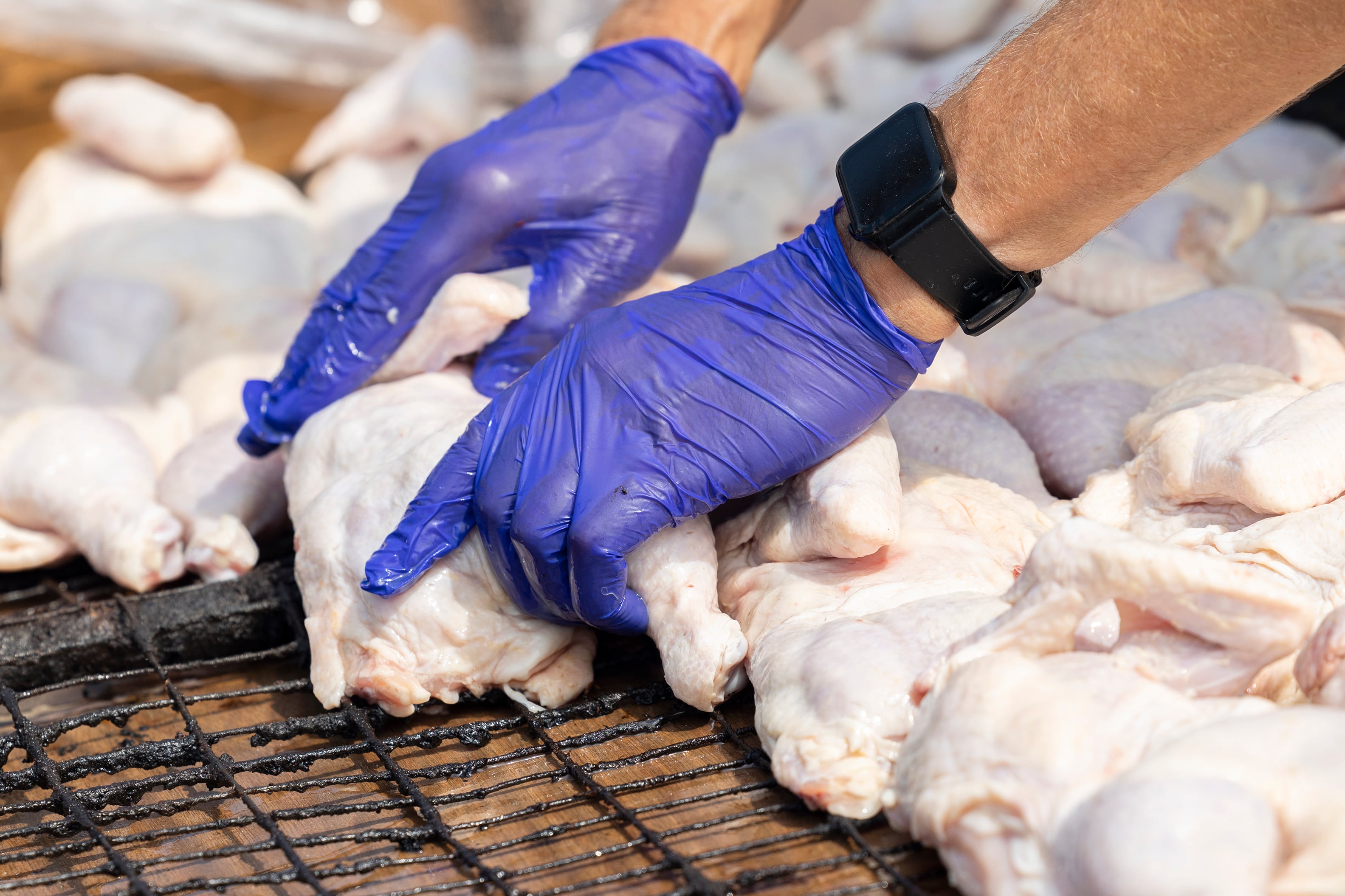 Chicken halves are placed 30 at time on barbecue racks Monday, Aug. 5, 2024, outside of the Sterling American Legion.