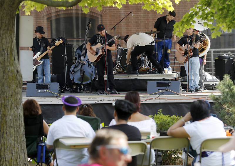 People listen to music of Es La Renueva during the annual Hispanic Connections Mexican Independence Day Celebration on Sunday, Sept. 15, 2024, in the Historic Woodstock Square. The celebration featured music, food and culture.