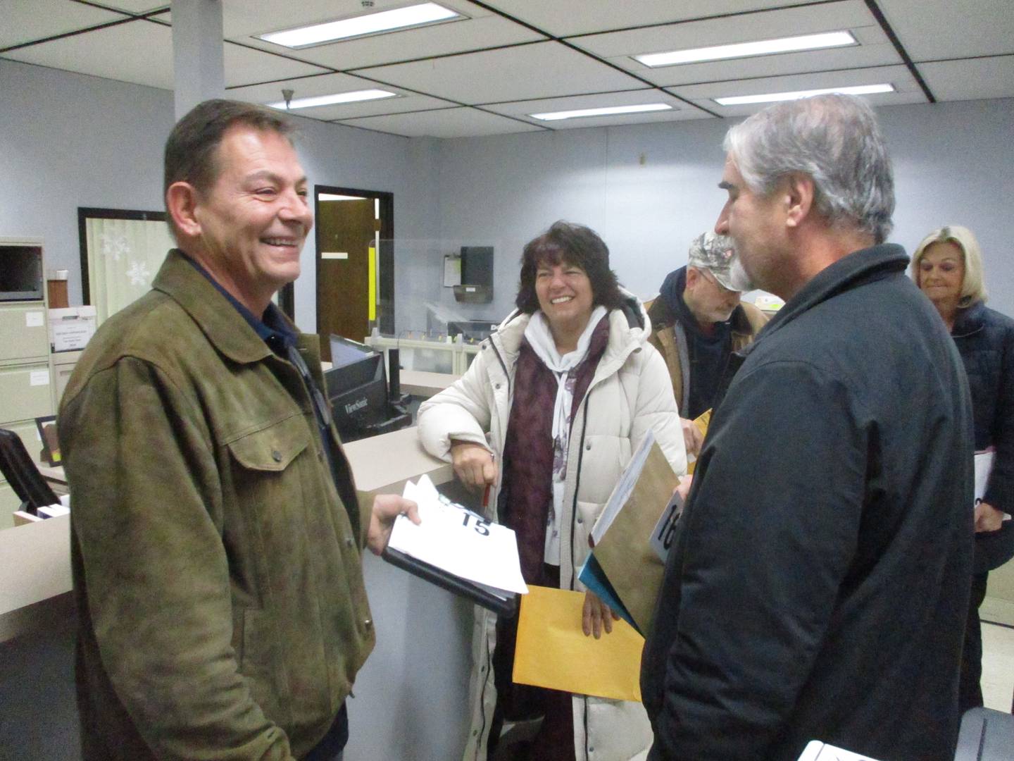 Candidates (from left) Curt Mason, a Homer Glen trustee seeking a precinct committeeman post, Dawn Buillock running for Will County Board, and Dave Sinkus, seeking a precinct committeeman post in Homer Township enjoy a moment while waiting in line to file their petitions for candidacy Monday, Nov. 27, 2023, at the Will County Clerk's office.