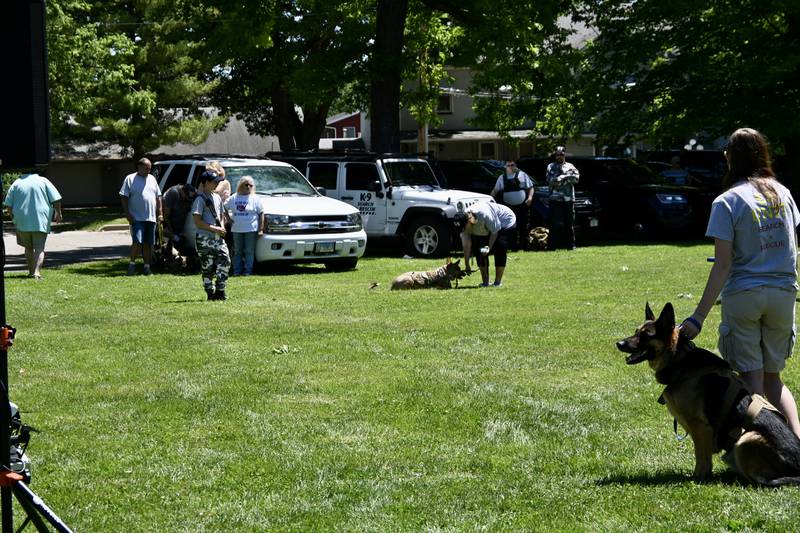 Attendees watch K9 Britta Jane, a Female German Shepherd, lay down after finding a quarter with a human scent as a part of the Central K9 Search and Rescue, of Spring Valley, demonstration on Saturday's Bark in the Park.