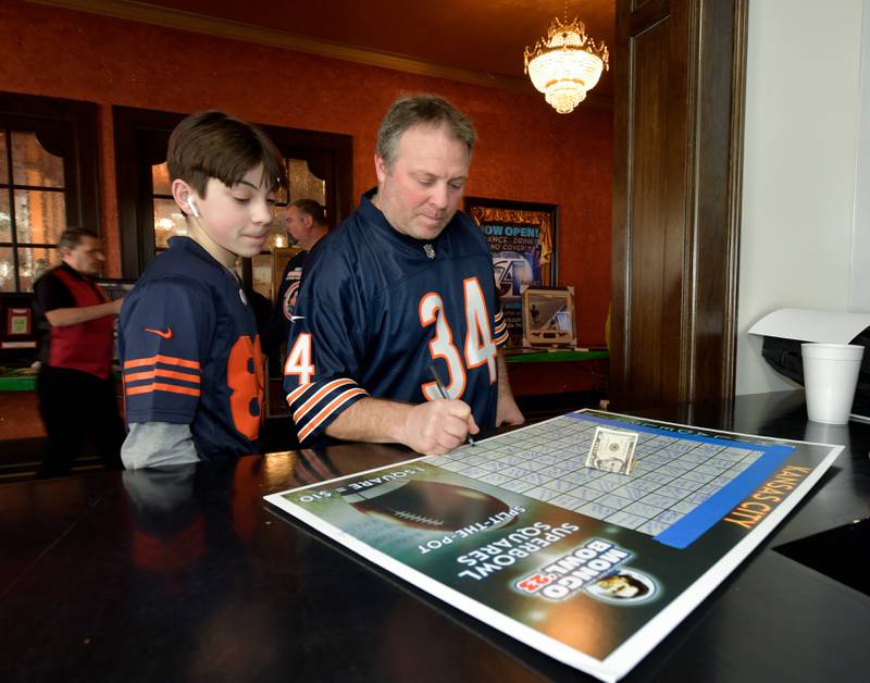 Johnny Rigali, 13 and his dad John Rigali choose a Super Bowl square during the Arcada Theatre’s “Mongo Bowl 23” fundraiser for former Chicago Bears player Steve “Mongo” McMichael, who has ALS, on Sunday, Feb. 12, 2023.