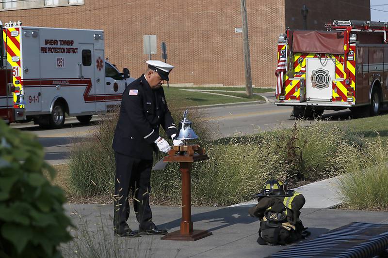 McHenry Fire Protection District Lt. Johnie Downey rings a bell to honor firefighters who died on 9/11 during a remembrance ceremony on Sept. 11, 2024, at Veteran's Memorial Park in McHenry.