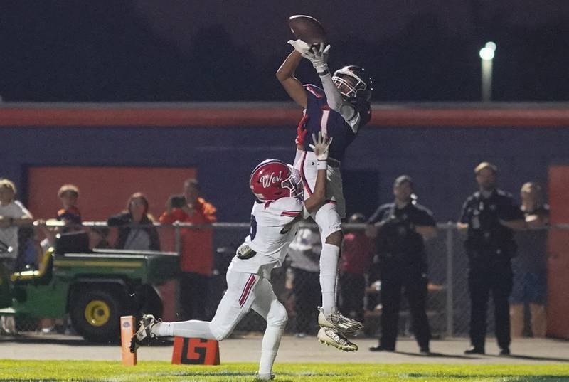 Oswego’s Jeremiah Cain (1) catches a pass for a touchdown against West Aurora's Jayden Garcia (8) during a football game at Oswego High School on Friday, Sept. 29, 2023.