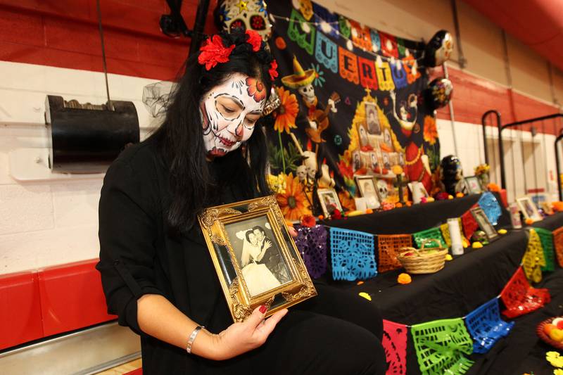 Yesenia Flory, of Fox Lake holds a photo of her parents, Maria Lerma and Armando Navarro, displayed on an altar during the Dia de los Muertos, Day of the Dead event at Stanton Middle School on November 4th in Fox Lake. The event was sponsored by Bilingual Parents Advisory Committee (BPAC) from School Districts 114,124 and 37.Flory works at the Lotus Elementary School in Spring Grove.
Photo by Candace H. Johnson for Shaw Local News Network