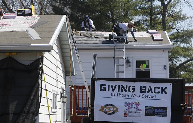 Workers from Feldco replace the roof of U.S. Army veteran Robin Waltrip’s home in Island Lake on Monday April 8, 2024, as part of the Owens Corning Roof Deployment Project. The Owens Corning Foundation is donating roofing materials and Feldco is donating the labor.