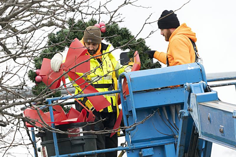 Dixon street department’s Steve Fassler (left) and Austin Clark work to remove the holiday decorations Wednesday, Jan. 3, 2024 from the downtown. The decorations were put up just before Thanksgiving.