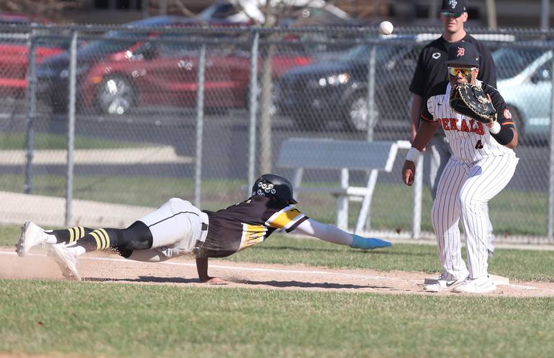 Metea Valley's Jayden Malone dives back to first as DeKalb's Maddux Clarence takes the throw during their game Thursday, April 13, 2023, at DeKalb High School.