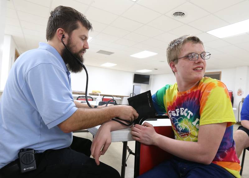 EMT Basic student Rob Mellentine checks blood pressure on special needs student Matthew Schennum on Thursday, March 7, 2024 at the McNabb Fire Department. EMT Basic students trained with special needs students in Putnam County on how to work with the special needs kids so they will feel more comfortable and understand what will happen in an emergency. The training gave the EMT Basic students hands-on training on working with the special need students.