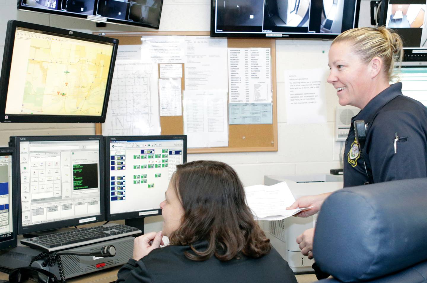 Peru Police commander Sarah Raymond,(right) smiles while taking in the dispatch room at the Peru Police Station.