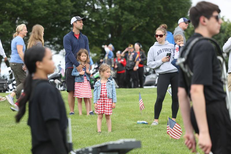 The Tutich family watches as Plainfield North’s marching band passes by at Plainfield’s Memorial Day and Ceremony event on Monday, May 27, 2024.