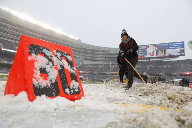 Workers clear snow from Soldier Field before a game between the Chicago Bears and Cleveland Browns onSunday, Dec. 24, 2017 in Chicago.