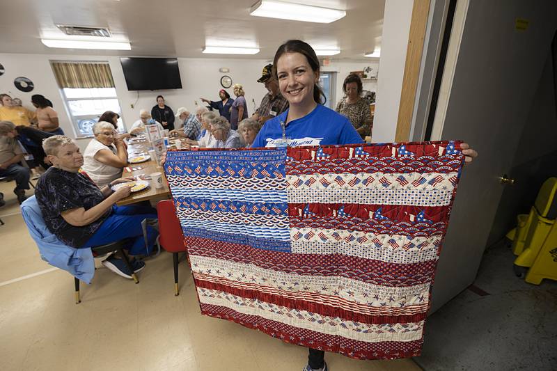 Chandra Howard, Rock River Hospice marketing director, displays a quilt made by the senior center quilting group that will be given away Thursday, July 11, 2024. at the Whiteside County Senior Center.