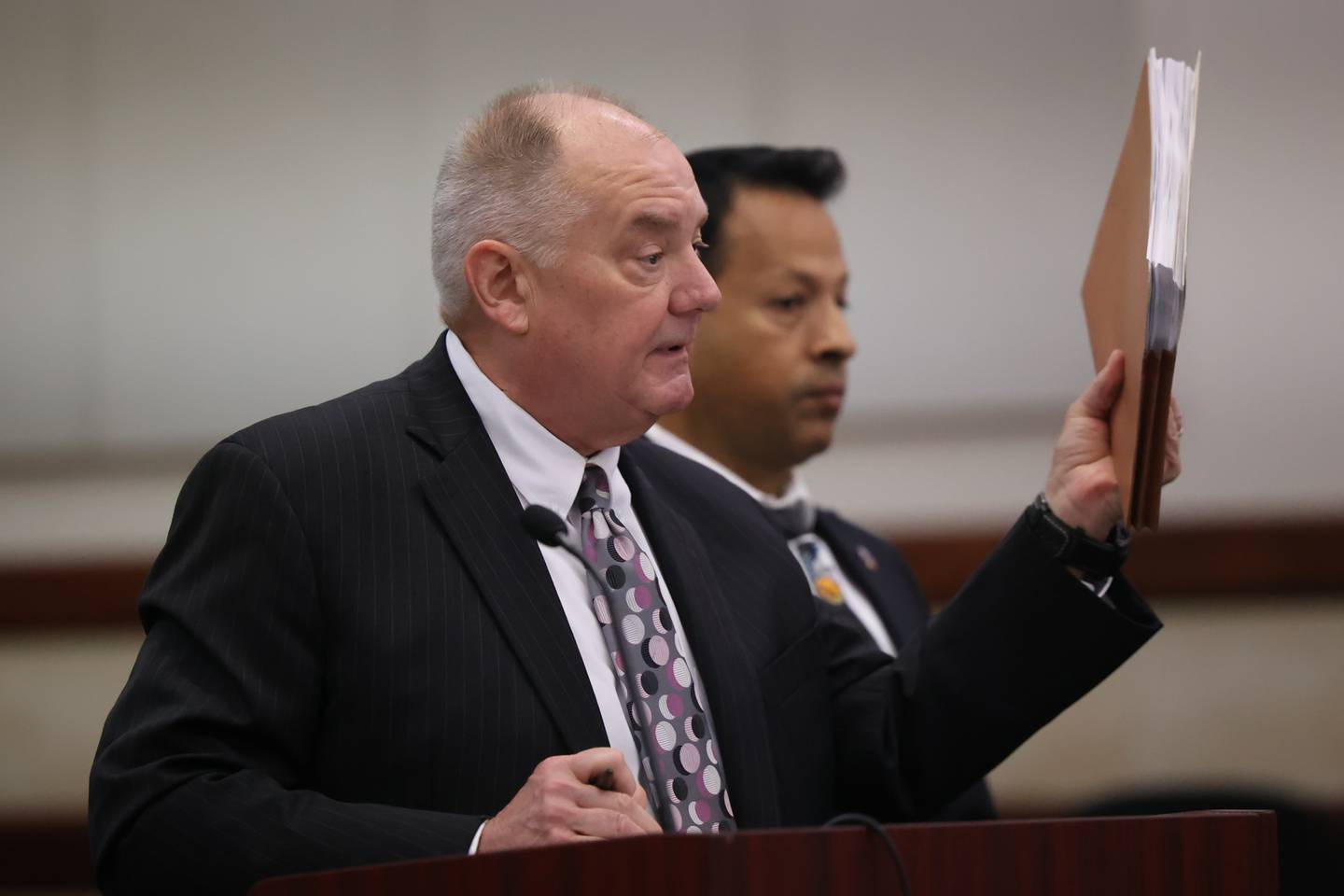 Defense attorney Jeff Tomczak holds up documents for the  judge during a status hearing for Javier Esqueda at the Kendall County Courthouse. Esqueda faces official misconduct charges for leaking video of Eric Lurry’s arrest. Lurry died from a drug overdose. Tuesday, June 14, 2022 in Yorkville.