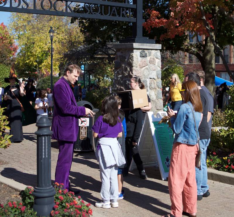 Attendees watch magic tricks at Witches and Wizards of Woodstock on Sunday, Oct. 20, 2024 in Woodstock.