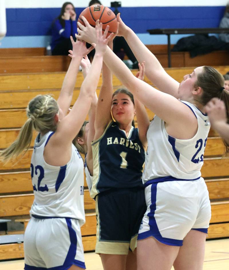 Harvest Christian’s Sophie Lang tries to get control of the ball between three Hinckley-Big Rock defenders Monday, Jan. 8, 2023, during their game at Hinckley-Big Rock High School.