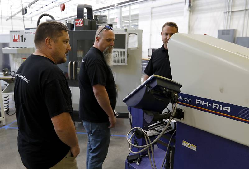 Colton Moran, Mike Krass, and Dyan Ryan from Sonoco|TEQ, look at optical comparator as they tour the Foglia Center for Advanced Technology and Innovation on Tuesday, Sept. 3, 2024, at McHenry County College.