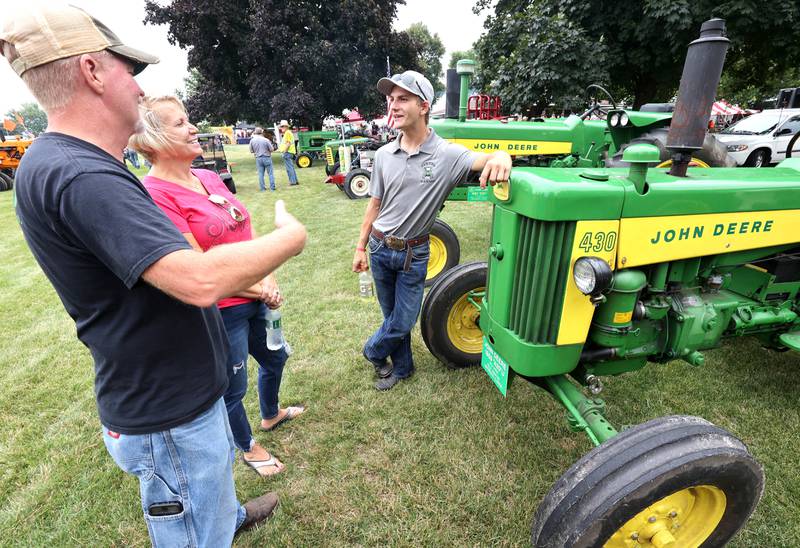 Kevin, (left) and Kristine Sawyer, from Waterman, chat with their son Wiley, 21, around their 1959 John Deere tractor Saturday, July 16, 2022, at the Waterman Lions Summerfest and Antique Tractor and Truck Show at Waterman Lions Club Park.