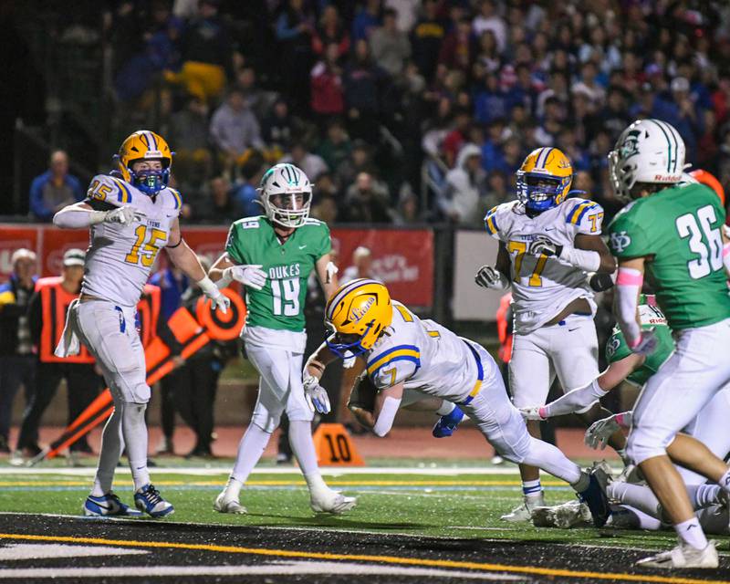 Lyons Township's Danny Carroll (7) dives into the endzone for a touchdown during the game on Friday Oct. 18, 2024, while traveling to take on York High School in Elmhurst.