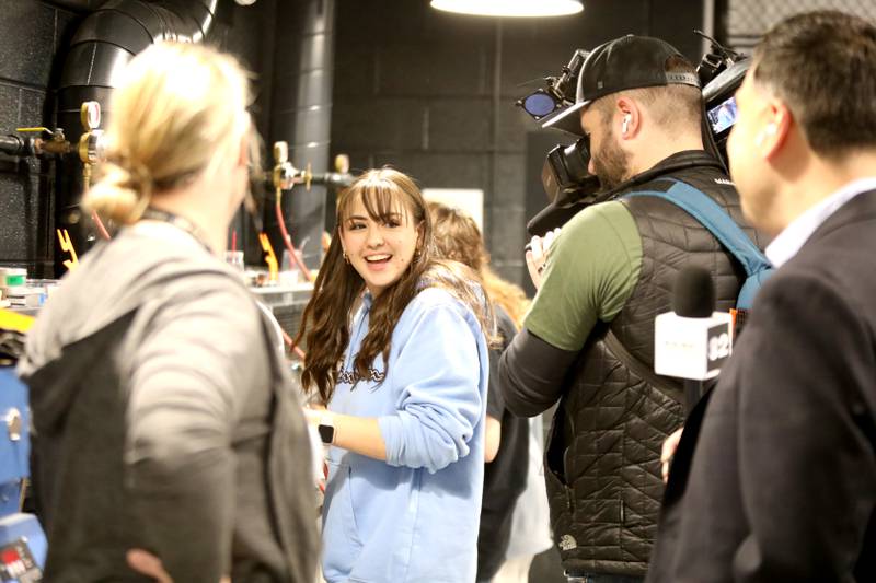 Downers Grove South student Sophia Pavlovski demonstrates making jewelry while on camera for Albert Ramon, chief meteorologist for CBS2 Chicago, as part of the television station’s day-long school spotlight coverage on Friday, Feb. 23, 2024.