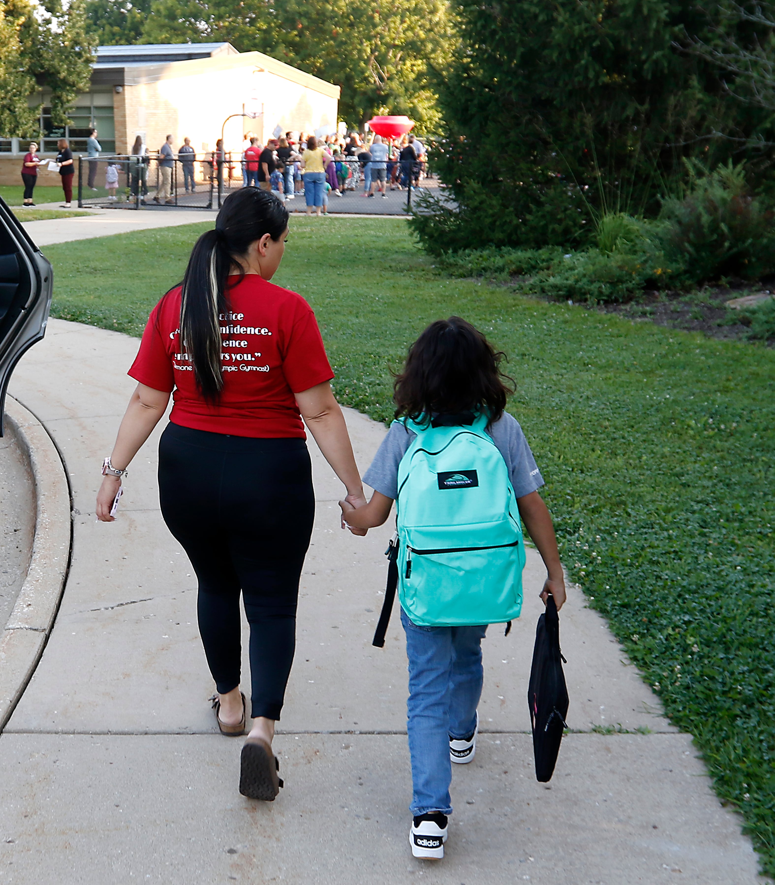 Sandy Carbajal walks her son, Bryan Cruz, 7, to Olson Elementary School on the first day of school  in Woodstock on Wednesday, Aug. 14, 2024.