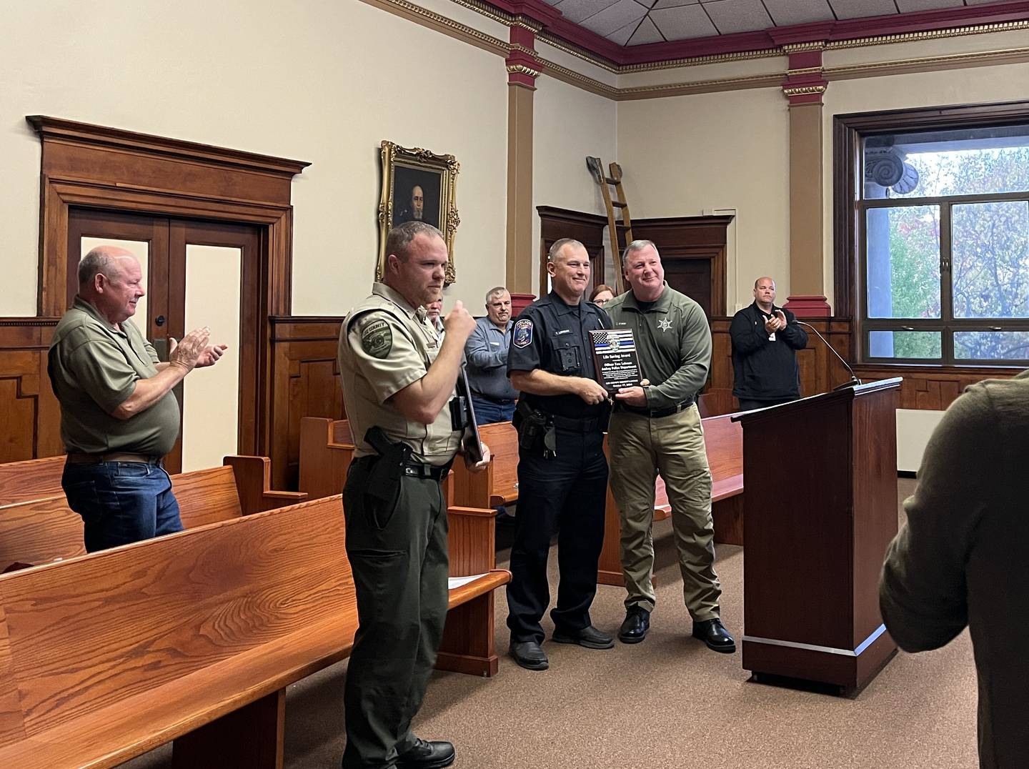 Lee County Sheriff Clay Whelan (right) presented the life saving awards to Amboy Officer Tom Lehman (left) and Corporal Kyle Kellen at a Lee County Board meeting Thursday, Oct. 17, 2024. The two officers revived Roberta Glenn after she suddenly collapsed, unconscious behind the bar at Last Alarm in Amboy during the August Depot Days Parade.